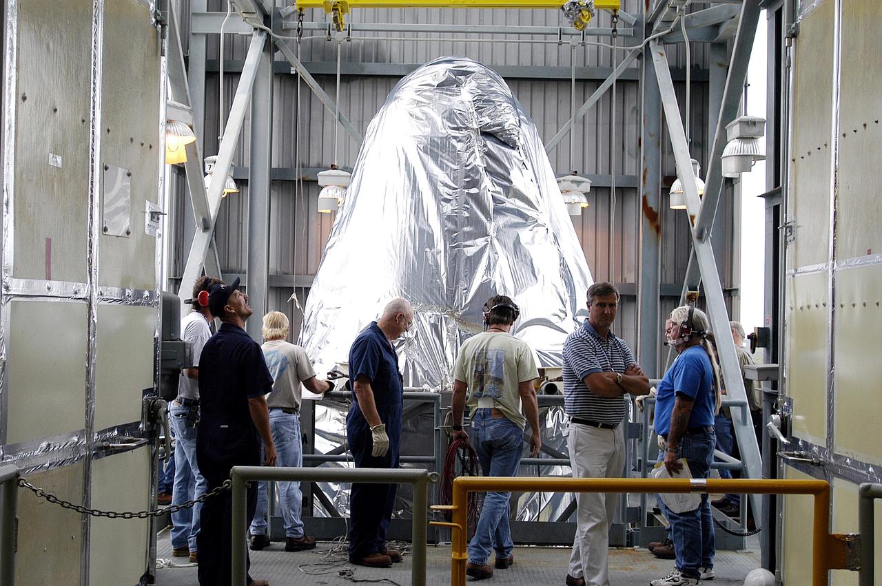 KENNEDY SPACE CENTER, FLA. - At Launch Complex 17-A, Cape Canaveral Air Force Station, the first half of the fairing for the Mars Exploration Rover 2 (MER-2/MER-A) reaches the top of the launch tower.  The fairing will be installed around the payload for protection during launch.  The MER Mission consists of two identical rovers designed to cover roughly 110 yards each Martian day over various terrain. Each rover will carry five scientific instruments that will allow it to search for evidence of liquid water that may have been present in the planet's past.  Identical to each other, the rovers will land at different regions of Mars.  Launch date for MER-A  is scheduled for June 5.