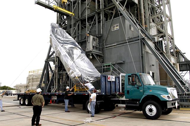 NASA image: KENNEDY SPACE CENTER, FLA. - After arriving at Launch Complex 17-A, Cape Canaveral Air Force Station, the second half of the fairing for the Mars Exploration Rover 2 (MER-2/MER-A) is lifted off its transporter.  The fairing will be installed around the payload for protection during launch.  The MER Mission consists of two identical rovers designed to cover roughly 110 yards each Martian day over various terrain. Each rover will carry five scientific instruments that will allow it to search for evidence of liquid water that may have been present in the planet's past.  Identical to each other, the rovers will land at different regions of Mars.  Launch date for MER-A  is scheduled for June 5.
