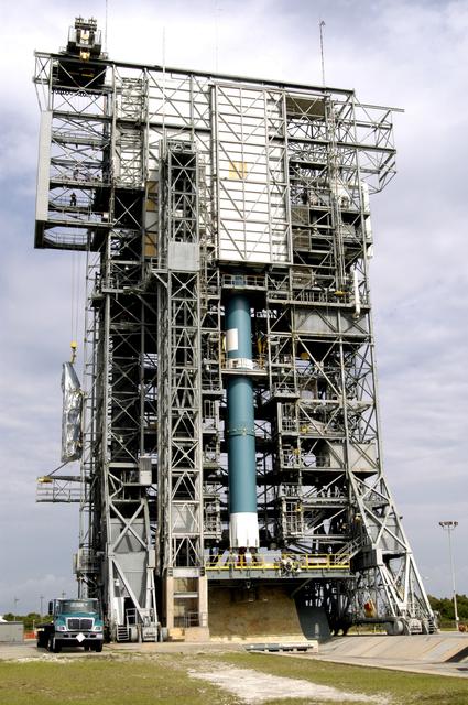 NASA image: KENNEDY SPACE CENTER, FLA. - At Launch Complex 17-A, Cape Canaveral Air Force Station, the second half of the fairing for the Mars Exploration Rover 2 (MER-2/MER-A) is lifted up the outside of the launch tower.  Visible on another side is the Delta II rocket that will carry the payload into space.  The fairing will be installed around the payload for protection during launch.  The MER Mission consists of two identical rovers designed to cover roughly 110 yards each Martian day over various terrain. Each rover will carry five scientific instruments that will allow it to search for evidence of liquid water that may have been present in the planet's past.  Identical to each other, the rovers will land at different regions of Mars.  Launch date for MER-A  is scheduled for June 5.
