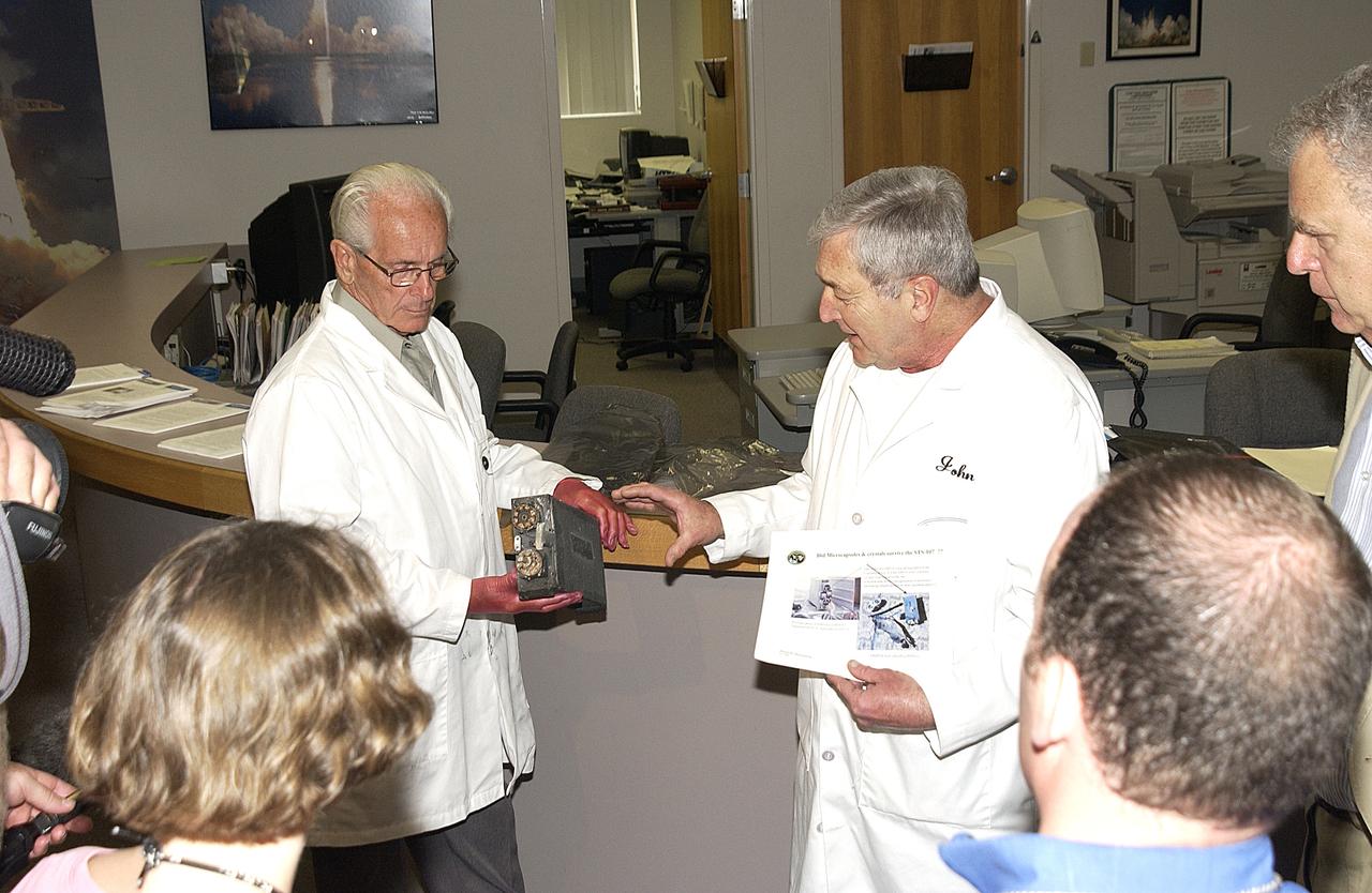 George D'Heilly and John Cassanto, scientists with Instrumentation Technology Associates, Inc., display for the media part of the apparatus recovered during the search for Columbia debris. It was part of the Commercial ITA Biomedical Experiments payload on mission STS-107 that included the Growth of Bacterial Biofilm on Surfaces during Spaceflight (GOBBSS) experiment and crystals grown for cancer research. The GOBBSS experiment was sponsored by the Planetary Society, with joint participation of an Israeli and a Palestinian student, and developed by the Israeli Aerospace Medical Institute and JSC Astrobiology Center.