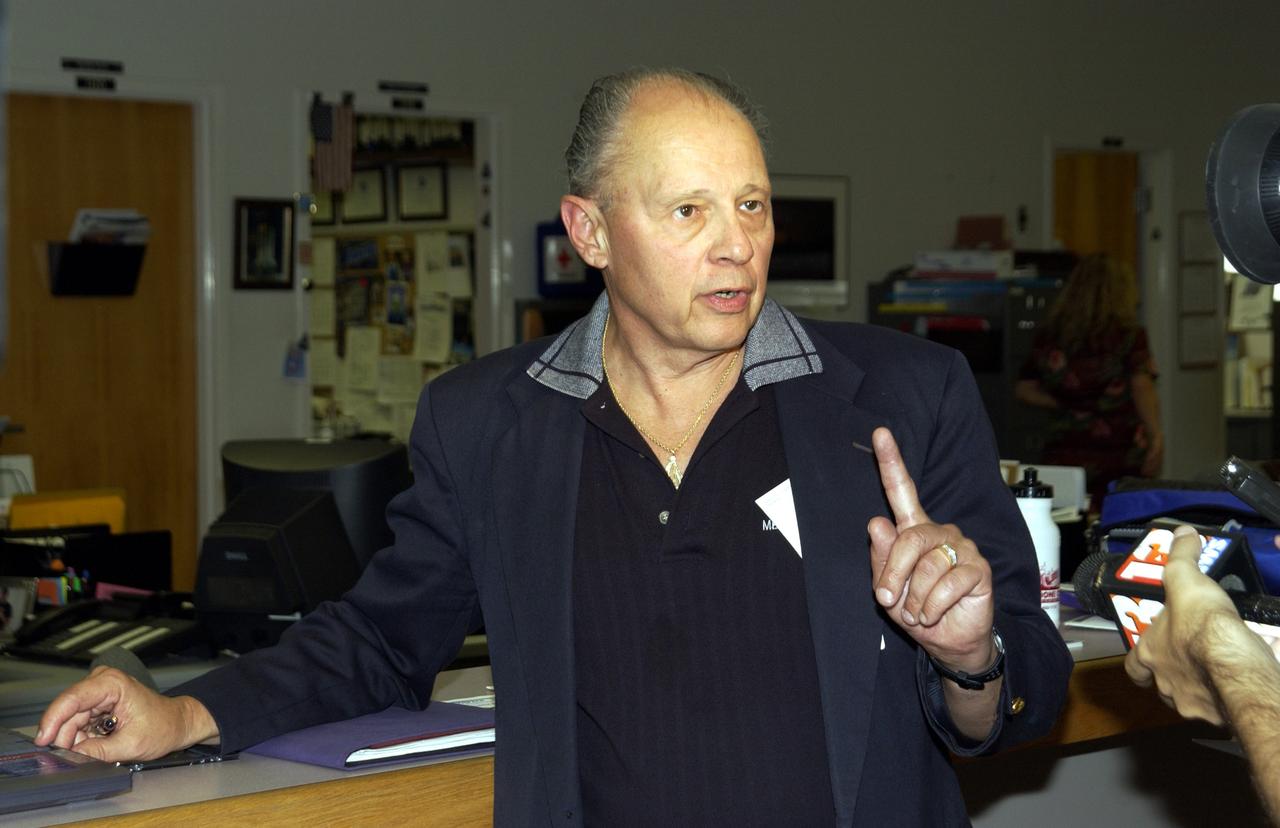 KENNEDY SPACE CENTER, FLA. - Dennis Morrison, senior biotech program scientist, talks to a reporter about an experiment recovered during the search for Columbia debris.  He is the principle investigator on microencapsulation and urokinase crystal growth included in the Commercial ITA Biomedical Experiments payload on mission STS-107.