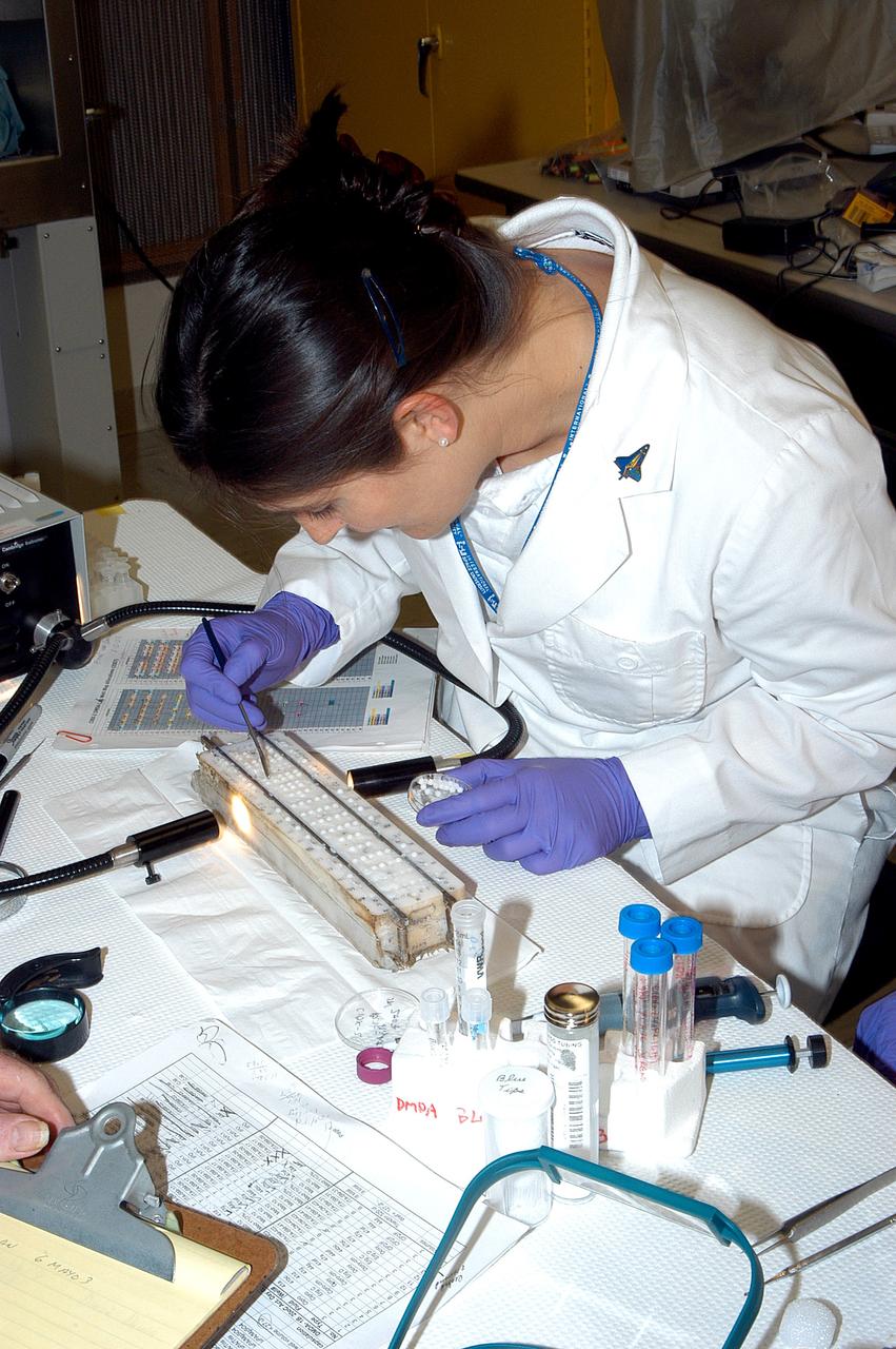 KENNEDY SPACE CENTER, FLA. -  Valerie Cassanto, with Instrumentation Technology Associates, Inc., works on an experiment found during the search for Columbia debris.  Included in the Commercial ITA Biomedical Experiments payload on mission STS-107 are urokinase cancer research, microencapsulation of drugs, the Growth of Bacterial Biofilm on Surfaces during Spaceflight (GOBBSS), and tin crystal formation.