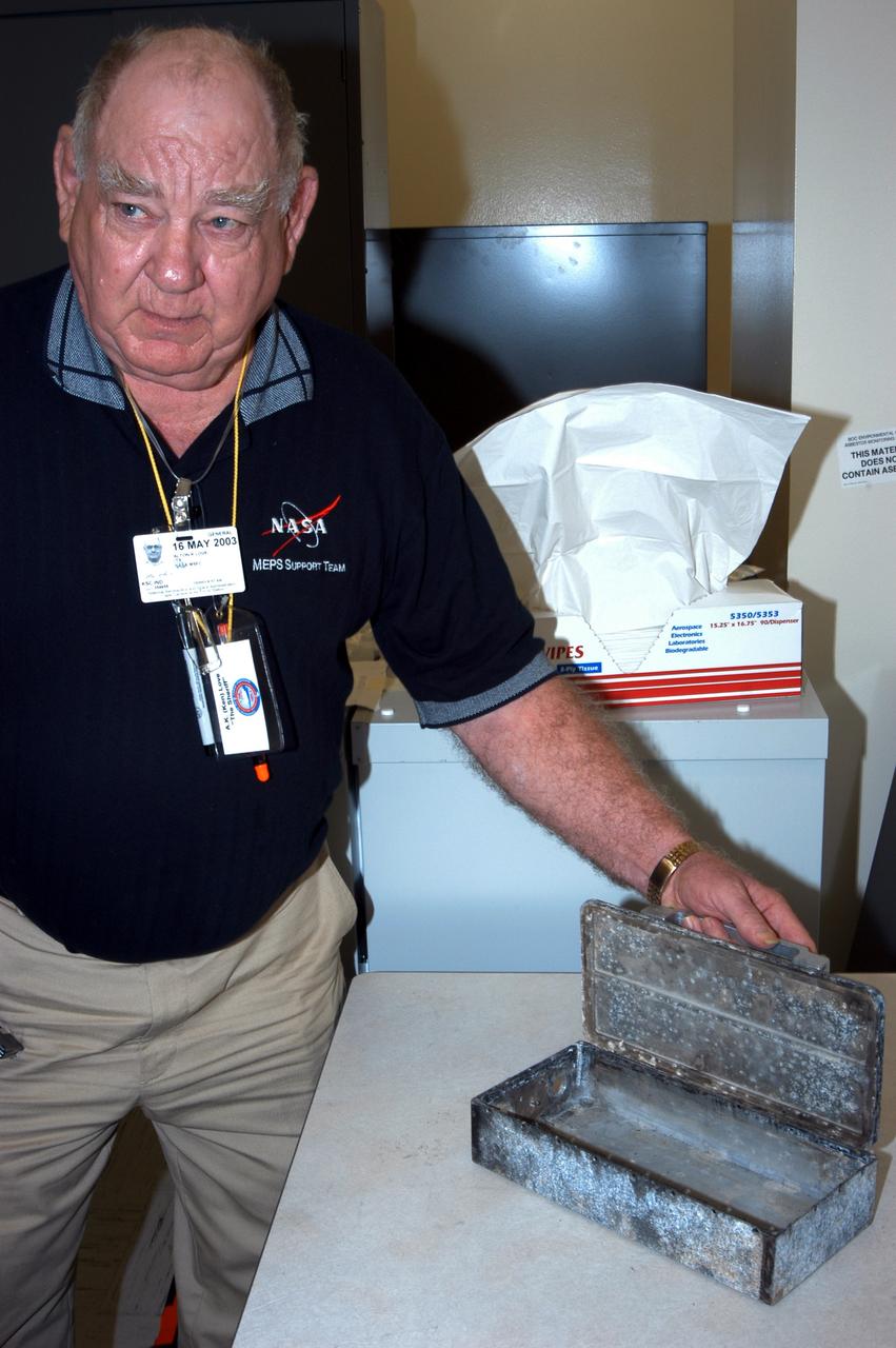 KENNEDY SPACE CENTER, FLA. -  A.K. Love,  with Instrumentation Technology Associates, Inc., displays one of the boxes used for cancer cell research, an experiment carried on mission STS-107.  Several experiments were found during the search for Columbia debris.  Included in the Commercial ITA Biomedical Experiments payload on mission STS-107 are urokinase cancer research, microencapsulation of drugs, the Growth of Bacterial Biofilm on Surfaces during Spaceflight (GOBBSS), and tin crystal formation.