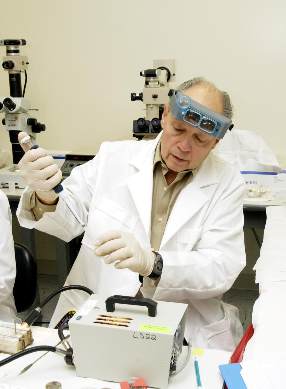 KENNEDY SPACE CENTER, FLA. -  Dr. Dennis Morrison, NASA Johnson Space Center, processes one of the experiments carried on mission STS-107. Several experiments were found during the search for Columbia debris. Included in the Commercial ITA Biomedical Experiments payload on mission STS-107 are urokinase cancer research, microencapsulation of drugs, the Growth of Bacterial Biofilm on Surfaces during Spaceflight (GOBBSS), and tin crystal formation.