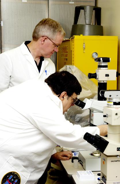 NASA image: KENNEDY SPACE CENTER, FLA. -  Barry Perlman, Pembroke Pines Charter Middle School in Florida, examines one of the experiments carried on mission STS-107 as Bob McLean, Southwest Texas State University, looks on. Several experiments were found during the search for Columbia debris. Included in the Commercial ITA Biomedical Experiments payload on mission STS-107 are urokinase cancer research, microencapsulation of drugs, the Growth of Bacterial Biofilm on Surfaces during Spaceflight (GOBBSS), and tin crystal formation.  The latter was sponsored by the Pembroke Pines Charter Middle School.