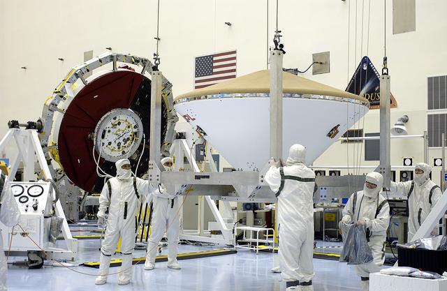NASA image: KENNEDY SPACE CENTER, FLA. - An overhead crane moves the Mars Exploration Rover 2 (MER-2) entry vehicle across the Payload Hazardous Servicing Facility toward a spin table for a dry-spin test.  The MER Mission consists of two identical rovers designed to cover roughly 110 yards each Martian day over various terrain. Each rover will carry five scientific instruments that will allow it to search for evidence of liquid water that may have been present in the planet's past.  Identical to each other, the rovers will land at different regions of Mars.  Launch for MER-2 (MER-A) is scheduled for June 5.
