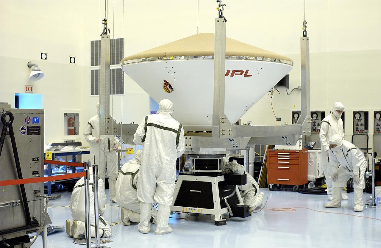 KENNEDY SPACE CENTER, FLA. - The overhead crane settles the Mars Exploration Rover 2 (MER-2) entry vehicle onto a spin table for a dry-spin test.  The MER Mission consists of two identical rovers designed to cover roughly 110 yards each Martian day over various terrain. Each rover will carry five scientific instruments that will allow it to search for evidence of liquid water that may have been present in the planet's past.  Identical to each other, the rovers will land at different regions of Mars.  Launch for MER-2 (MER-A) is scheduled for June 5.