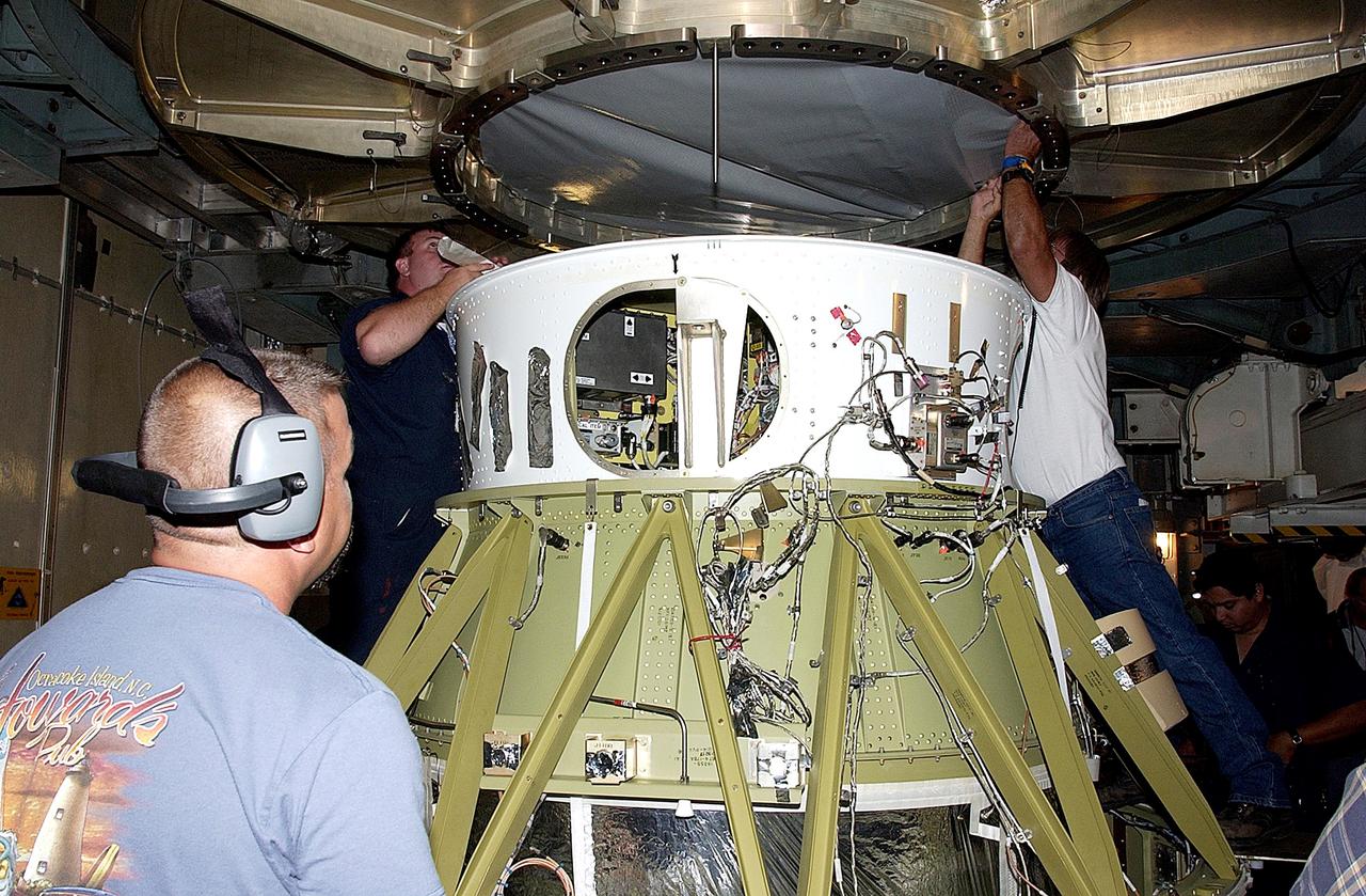 KENNEDY SPACE CENTER, FLA. -  Workers on Launch Complex 17-B, Cape Canaveral Air Force Station, start dismantling the Space Infrared Telescope Facility (SIRTF) observatory from atop the Delta II rocket.  It will be taken back to NASA Spacecraft Hangar AE. SIRTF will remain in the clean room at Hangar AE until it returns to the pad in early August.