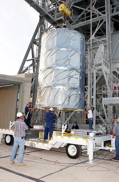 NASA image: KENNEDY SPACE CENTER, FLA. - On Launch Complex 17-B, Cape Canaveral Air Force Station, the Space Infrared Telescope Facility (SIRTF) observatory is lowered onto a transporter to be taken back to NASA Spacecraft Hangar AE. SIRTF will remain in the clean room at Hangar AE until it returns to the pad in early August.