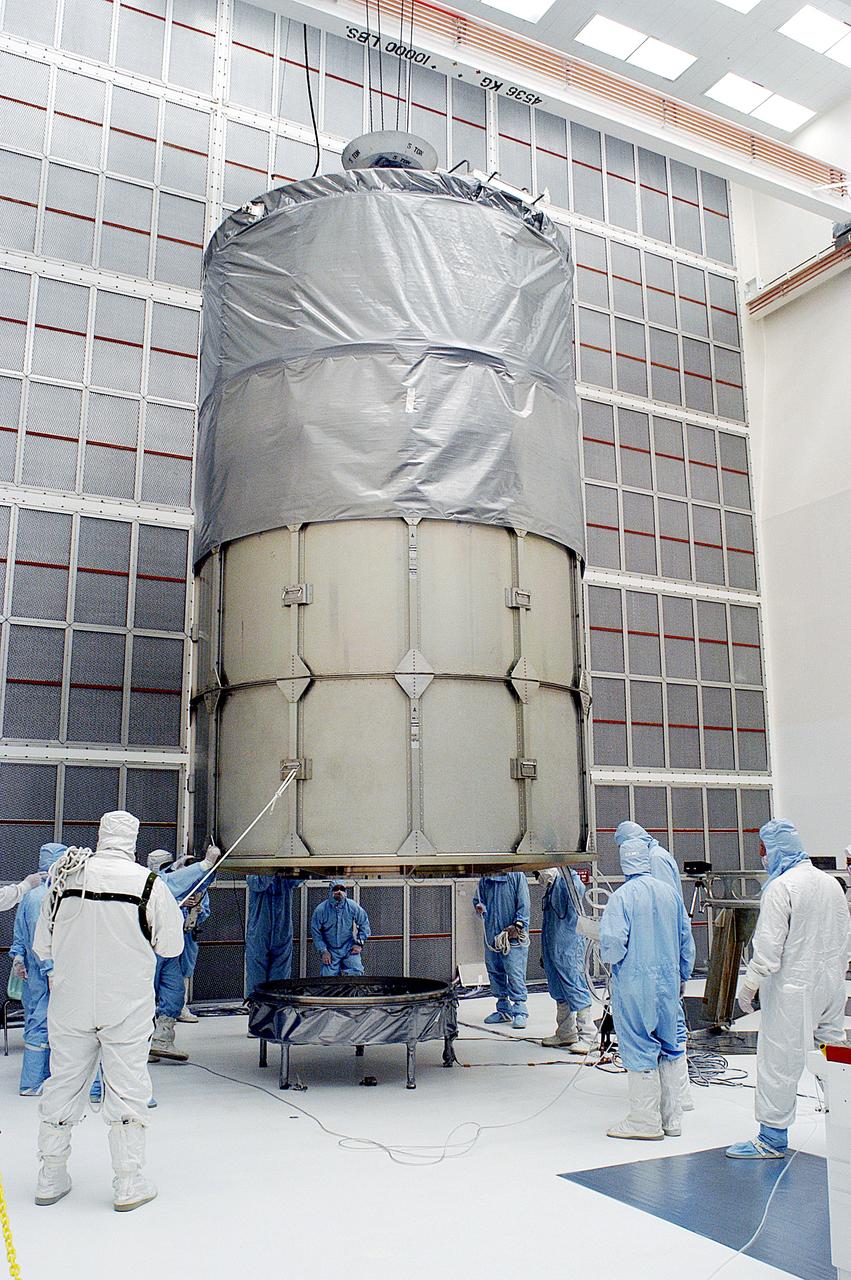 KENNEDY SPACE CENTER, FLA. -  Workers in NASA Spacecraft Hangar AE prepare to remove the canister from around the Space Infrared Telescope Facility (SIRTF), which has been returned to the hangar from the launch pad.   SIRTF will remain in the clean room until it returns to the pad in early August. One of NASA's largest infrared telescopes to be launched, SIRTF will obtain images and spectra by detecting the infrared energy, or heat, radiated by objects in space.