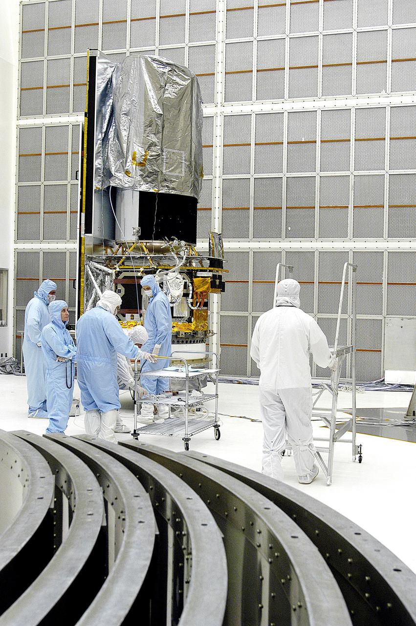 KENNEDY SPACE CENTER, FLA. -  Workers in NASA Spacecraft Hangar AE prepare to begin further processing of the Space Infrared Telescope Facility (SIRTF), which has been returned to the hangar from the launch pad. Sections of the transportation canister used in the move are in the foreground.  SIRTF will remain in the clean room until it returns to the pad in early August. One of NASA's largest infrared telescopes to be launched, SIRTF will obtain images and spectra by detecting the infrared energy, or heat, radiated by objects in space.