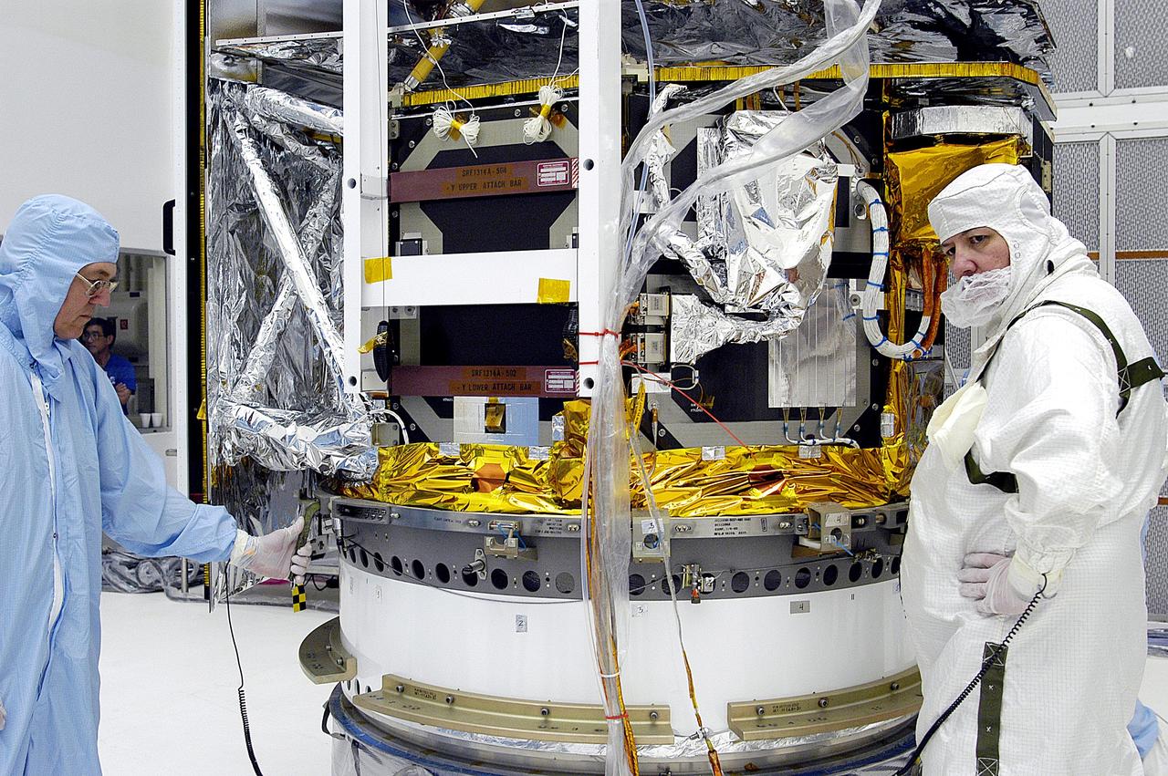 KENNEDY SPACE CENTER, FLA. -  Workers in NASA Spacecraft Hangar AE begin the next phase of processing of the Space Infrared Telescope Facility (SIRTF), which has been returned to the hangar from the launch pad. SIRTF will remain in the clean room until it returns to the pad in early August. One of NASA's largest infrared telescopes to be launched, SIRTF will obtain images and spectra by detecting the infrared energy, or heat, radiated by objects in space.