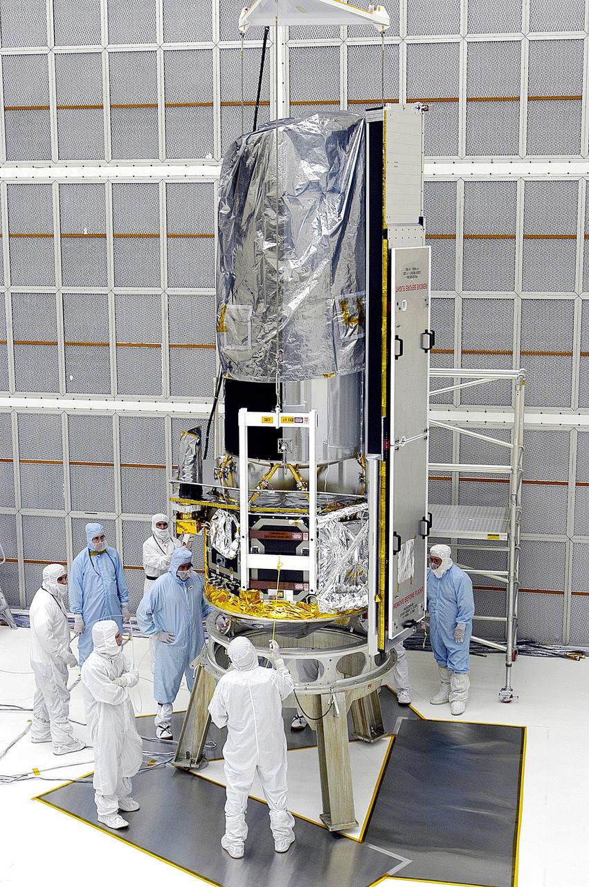 KENNEDY SPACE CENTER, FLA. -  Workers in NASA Spacecraft Hangar AE position the Space Infrared Telescope Facility (SIRTF), which has been returned to the hangar from the launch pad, for further processing. SIRTF will remain in the clean room until it returns to the pad in early August. One of NASA's largest infrared telescopes to be launched, SIRTF will obtain images and spectra by detecting the infrared energy, or heat, radiated by objects in space.