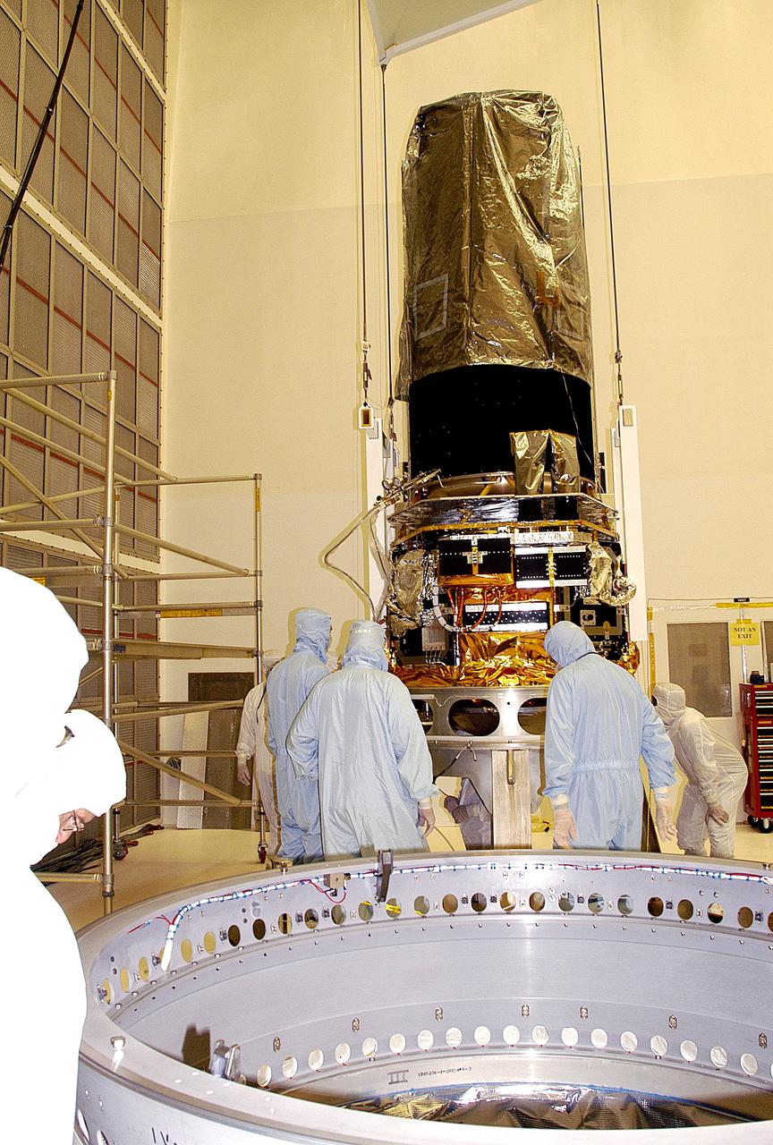 KENNEDY SPACE CENTER, FLA. -  Workers in NASA Spacecraft Hangar AE check the placement of the Space Infrared Telescope Facility (SIRTF), which has been returned to the hangar from the launch pad for further processing. SIRTF will remain in the clean room until it returns to the pad in early August. One of NASA's largest infrared telescopes to be launched, SIRTF will obtain images and spectra by detecting the infrared energy, or heat, radiated by objects in space.