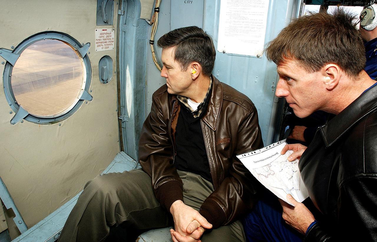 KAZAKHSTAN - From the seat of a Russian Helicopter, Bob Cabana (left), director of Flight Crew Operations, and astronaut Michael Foale (right) look out over the Kazakh terrain for the Expedition Six Soyuz capsule after its landing in Kazakhstan. The Soyuz was returning the Expedition Six crew after 161 days in space, 159 spent manning the International Space Station. Photo Credit: NASA/Bill Ingalls