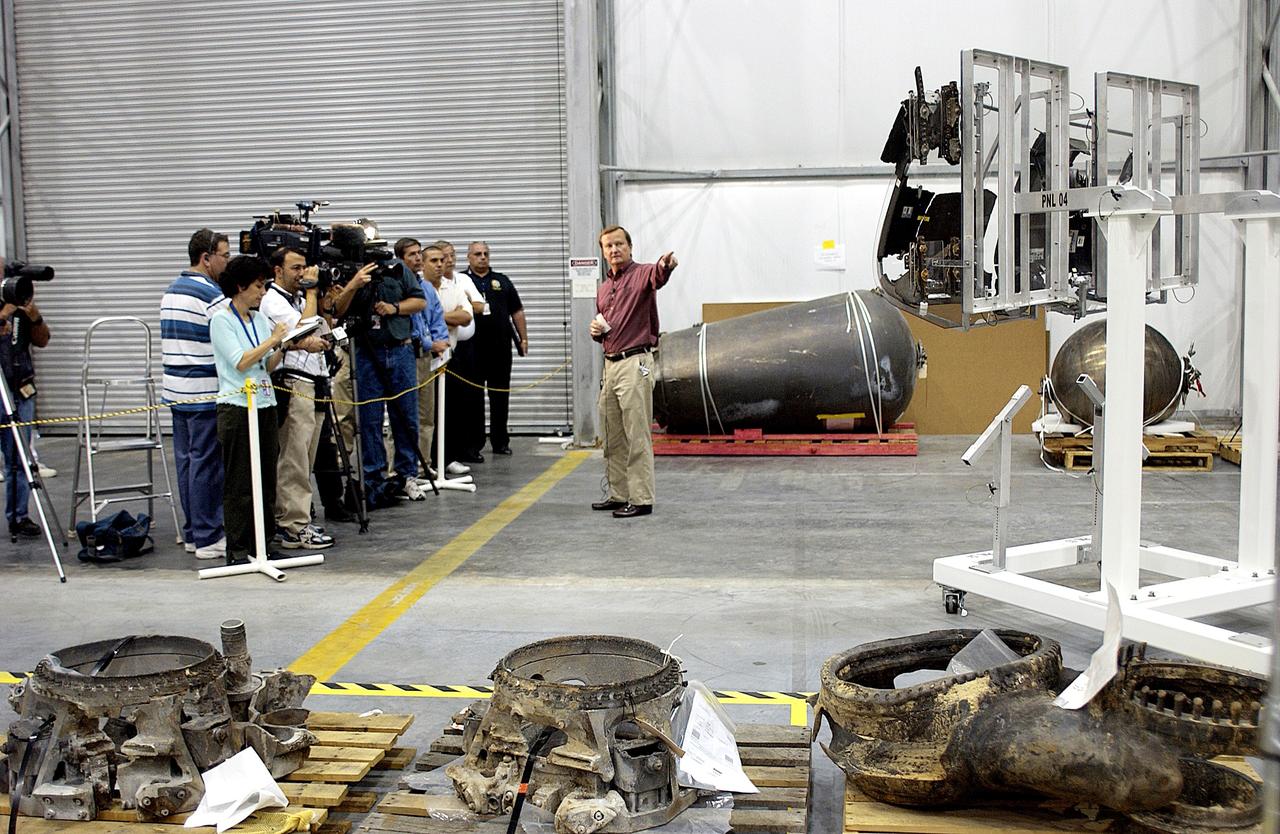 KENNEDY SPACE CENTER, FLA. - While talking to the media, Shuttle Launch Director Mike Leinbach points to some of the investigative tools in the RLV Hangar, where Columbia debris is being examined.  The items shipped to KSC number more than 82,000 and weigh 84,800 pounds or 38 percent of the total dry weight of Columbia.  Of those items, 78,760 have been identified, with 753 placed on the left wing grid in the Hangar.