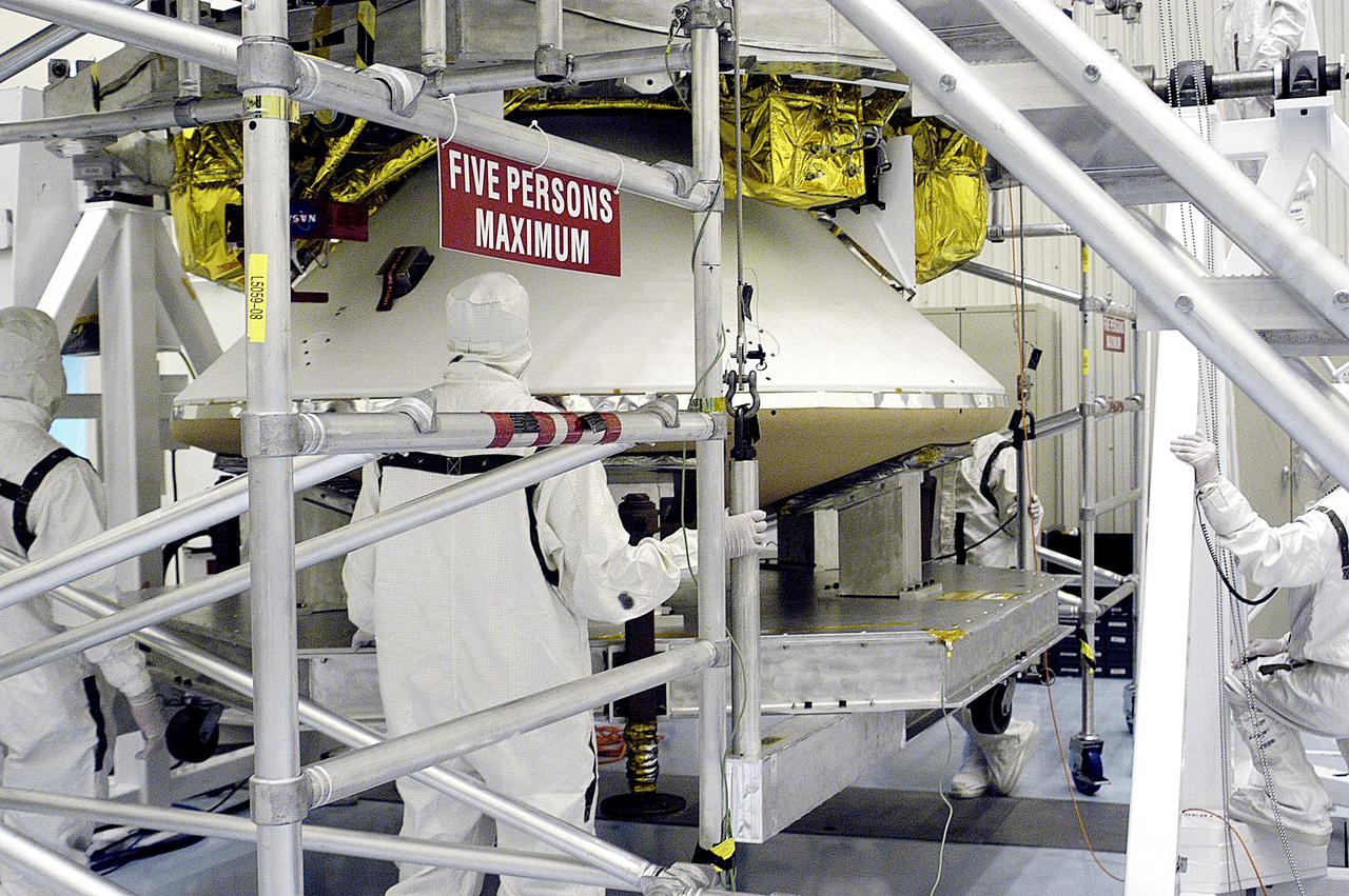 KENNEDY SPACE CENTER, FLA. - Workers in the  Payload Hazardous Servicing Facility stand by while the cruise stage is mated to the Mars Exploration Rover 2 (MER-2) entry vehicle.    The cruise stage includes fuel tanks, thruster clusters and avionics for steering and propulsion.  NASA's twin Mars Exploration Rovers are designed to study the history of water on Mars. These robotic geologists are equipped with a robotic arm, a drilling tool, three spectrometers, and four pairs of cameras that allow them to have a human-like, 3D view of the terrain. Each rover could travel as far as 100 meters in one day to act as Mars scientists' eyes and hands, exploring an environment where humans can't yet go.  MER-2 is scheduled to launch June 5 as MER-A aboard a Delta rocket from Cape Canaveral Air Force Station.