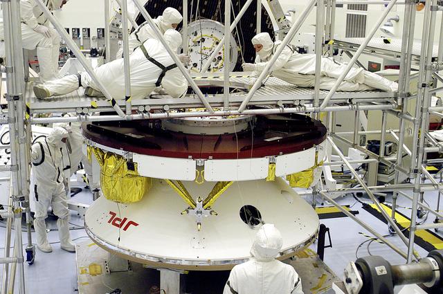 NASA image: KENNEDY SPACE CENTER, FLA. - Workers in the Payload Hazardous Servicing Facility prepare the Mars Exploration Rover 2 (MER-2) for a weight and center of gravity determination.  NASA's twin Mars Exploration Rovers are designed to study the history of water on Mars. These robotic geologists are equipped with a robotic arm, a drilling tool, three spectrometers, and four pairs of cameras that allow them to have a human-like, 3D view of the terrain. Each rover could travel as far as 100 meters in one day to act as Mars scientists' eyes and hands, exploring an environment where humans can't yet go.  Launch of MER-2 is scheduled for June 5 from Cape Canaveral Air Force Station.