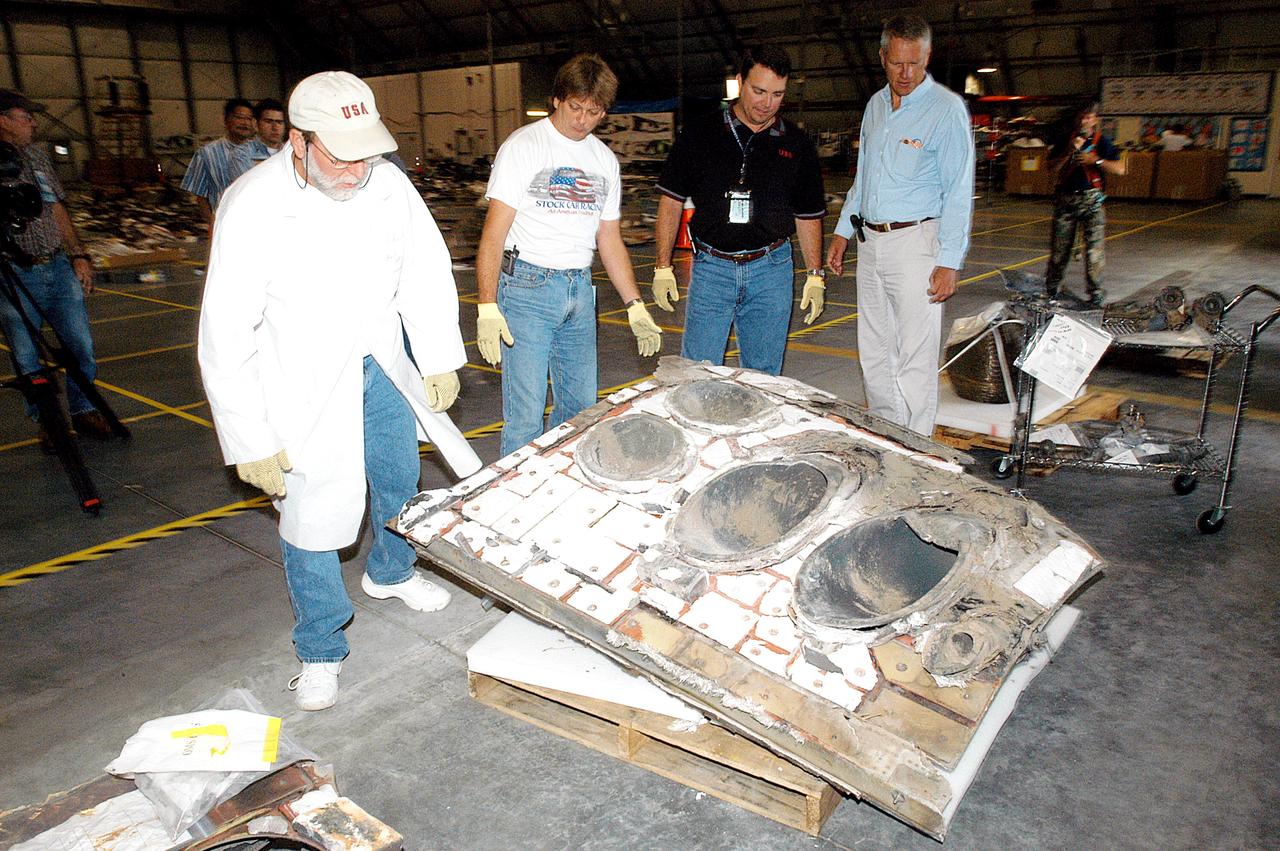 KENNEDY SPACE CENTER, FLA. -  Members of the Columbia Reconstruction Project Team work with pieces of debris in the RLV Hangar. The items shipped to KSC number more than 82,000 and weigh 84,800 pounds or 38 percent of the total dry weight of Columbia. Of those items, 78,760 have been identified, with 753 placed on the left wing grid in the Hangar.