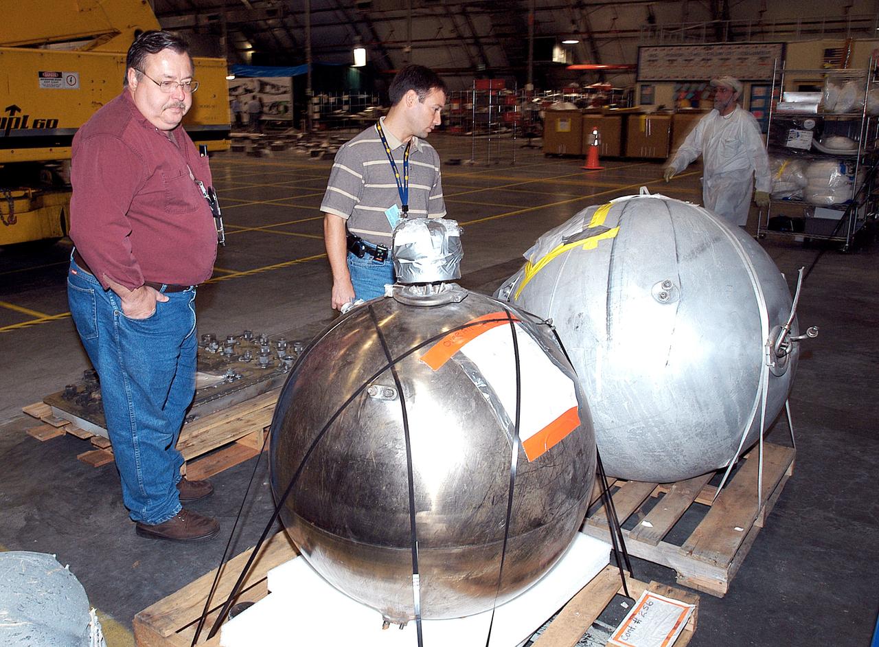 KENNEDY SPACE CENTER, FLA. -  Members of the Columbia Reconstruction Project Team examine pieces of debris in the RLV Hangar. The items shipped to KSC number more than 82,000 and weigh 84,800 pounds or 38 percent of the total dry weight of Columbia. Of those items, 78,760 have been identified, with 753 placed on the left wing grid in the Hangar.