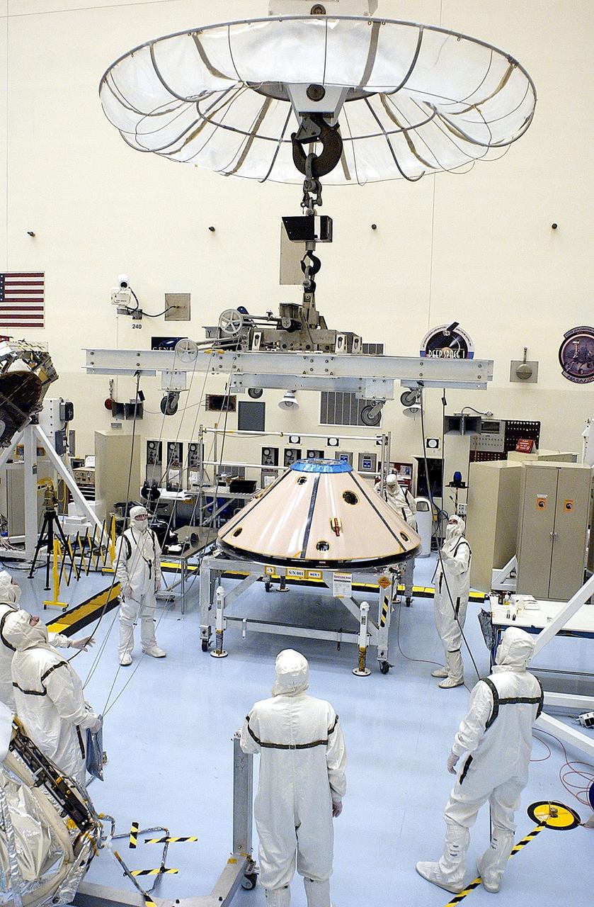 KENNEDY SPACE CENTER, FLA. -  Workers in the Payload Hazardous Servicing Facility prepare to lift and move the backshell that will cover the Mars Exploration Rover 1 (MER-1) and its lander.  NASA's twin Mars Exploration Rovers are designed to study the history of water on Mars. These robotic geologists are equipped with a robotic arm, a drilling tool, three spectrometers, and four pairs of cameras that allow them to have a human-like, 3D view of the terrain. Each rover could travel as far as 100 meters in one day to act as Mars scientists' eyes and hands, exploring an environment where humans can't yet go.  MER-1 is scheduled to launch June 25 as MER-B aboard a Delta II rocket from Cape Canaveral Air Force Station.
