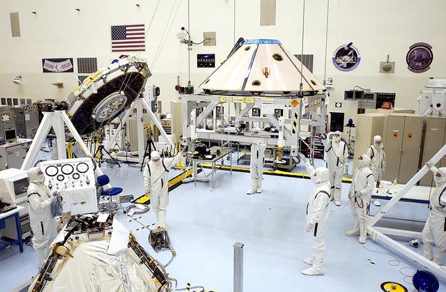 NASA image: The backshell for the Mars Exploration Rover 1 (MER-1) is moved toward the rover (foreground, left).  The backshell is a protective cover for the rover.  NASA's twin Mars Exploration Rovers are designed to study the history of water on Mars. These robotic geologists are equipped with a robotic arm, a drilling tool, three spectrometers, and four pairs of cameras that allow them to have a human-like, 3D view of the terrain. Each rover could travel as far as 100 meters in one day to act as Mars scientists' eyes and hands, exploring an environment where humans can't yet go.  MER-1 is scheduled to launch June 25 as MER-B aboard a Delta II rocket from Cape Canaveral Air Force Station.
