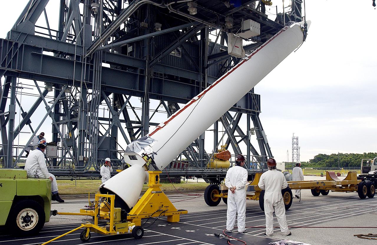 KENNEDY SPACE CENTER, FLA. - On Launch Complex 17-A, Cape Canaveral Air Force Station, a solid rocket booster is raised off the transporter.  When vertical, it will be lifted up the launch tower and mated to the Delta rocket (in the background) to launch Mars Exploration Rover 2. NASA’s twin Mars Exploration Rovers are designed to study the history of water on Mars. These robotic geologists are equipped with a robotic arm, a drilling tool, three spectrometers, and four pairs of cameras that allow them to have a human-like, 3D view of the terrain. Each rover could travel as far as 100 meters in one day to act as Mars scientists' eyes and hands, exploring an environment where humans can’t yet go.  MER-2 is scheduled to launch June 5 as MER-A.  MER-1 (MER-B) will launch June 25.