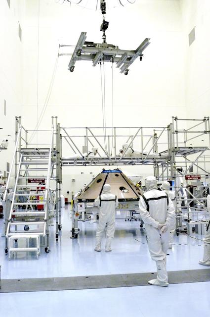 NASA image: KENNEDY SPACE CENTER, FLA. -  An overhead crane is attached to the Mars Exploration Rover 1 (MER-1) inside the upper backshell.   The backshell will be moved and attached to the lower heat shield.  NASA's twin Mars Exploration Rovers are designed to study the history of water on Mars. These robotic geologists are equipped with a robotic arm, a drilling tool, three spectrometers, and four pairs of cameras that allow them to have a human-like, 3D view of the terrain. Each rover could travel as far as 100 meters in one day to act as Mars scientists' eyes and hands, exploring an environment where humans can't yet go.  MER-1 is scheduled to launch June 25 as MER-B aboard a Delta II rocket from Cape Canaveral Air Force Station.