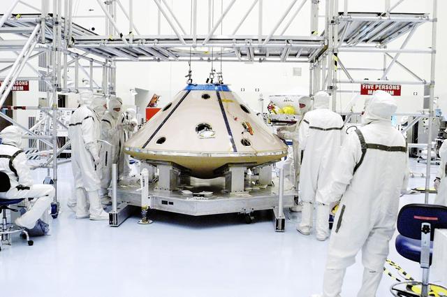 NASA image: KENNEDY SPACE CENTER, FLA. -  Assembly of the backshell and heat shield surrounding the Mars Exploration Rover 1 (MER-1) is complete.  The resulting aeroshell will protect the rover on its journey to Mars.  NASA's twin Mars Exploration Rovers are designed to study the history of water on Mars. These robotic geologists are equipped with a robotic arm, a drilling tool, three spectrometers, and four pairs of cameras that allow them to have a human-like, 3D view of the terrain. Each rover could travel as far as 100 meters in one day to act as Mars scientists' eyes and hands, exploring an environment where humans can't yet go.  MER-1 is scheduled to launch June 25 as MER-B aboard a Delta II rocket from Cape Canaveral Air Force Station.