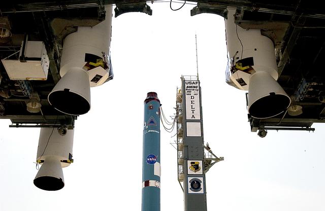 NASA image: KENNEDY SPACE CENTER, FLA. -  In the foreground, three solid rocket boosters (SRBs) suspended in the launch tower flank the Delta II rocket (in the background) that will launch Mars Exploration Rover 2 (MER-2).  NASA’s twin Mars Exploration Rovers are designed to study the history of water on Mars. These robotic geologists are equipped with a robotic arm, a drilling tool, three spectrometers, and four pairs of cameras that allow them to have a human-like, 3D view of the terrain. Each rover could travel as far as 100 meters in one day to act as Mars scientists' eyes and hands, exploring an environment where humans can’t yet go.  MER-2 is scheduled to launch June 5 as MER-A.  MER-1 (MER-B) will launch June 25.