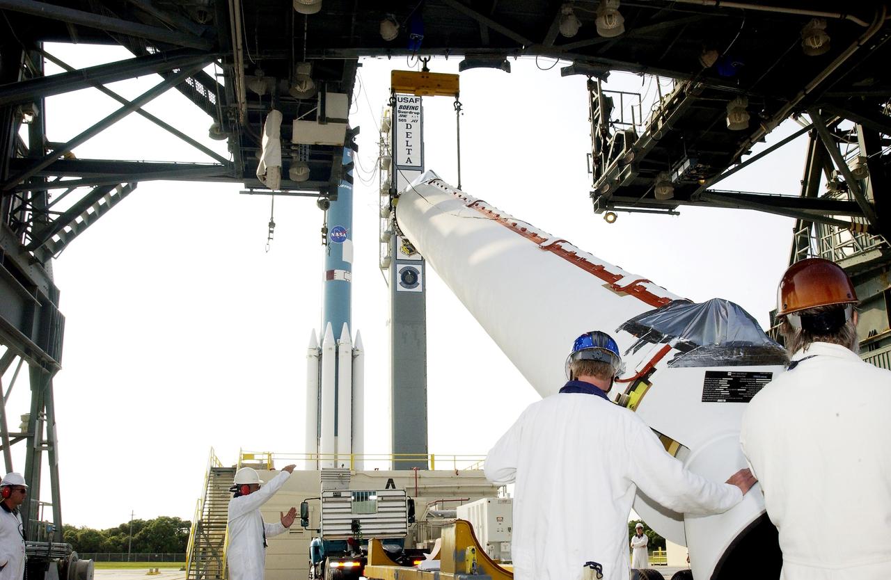 KENNEDY SPACE CENTER, FLA. -  Another solid rocket booster, in the foreground, is lifted off its transporter on Launch Complex 17-A, Cape Canaveral Air Force Station, for mating with the Delta II rocket in the background.  The SRB is one of nine that will help launch Mars Exploration Rover 2 (MER-2).  NASA’s twin Mars Exploration Rovers are designed to study the history of water on Mars. These robotic geologists are equipped with a robotic arm, a drilling tool, three spectrometers, and four pairs of cameras that allow them to have a human-like, 3D view of the terrain. Each rover could travel as far as 100 meters in one day to act as Mars scientists' eyes and hands, exploring an environment where humans can’t yet go.  MER-2 is scheduled to launch June 5 as MER-A.  MER-1 (MER-B) will launch June 25.