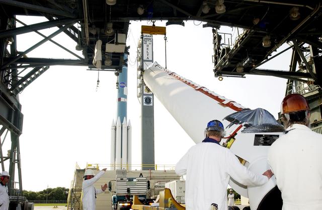 NASA image: KENNEDY SPACE CENTER, FLA. -  Another solid rocket booster, in the foreground, is lifted off its transporter on Launch Complex 17-A, Cape Canaveral Air Force Station, for mating with the Delta II rocket in the background.  The SRB is one of nine that will help launch Mars Exploration Rover 2 (MER-2).  NASA’s twin Mars Exploration Rovers are designed to study the history of water on Mars. These robotic geologists are equipped with a robotic arm, a drilling tool, three spectrometers, and four pairs of cameras that allow them to have a human-like, 3D view of the terrain. Each rover could travel as far as 100 meters in one day to act as Mars scientists' eyes and hands, exploring an environment where humans can’t yet go.  MER-2 is scheduled to launch June 5 as MER-A.  MER-1 (MER-B) will launch June 25.
