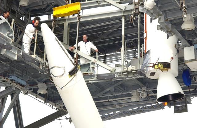 NASA image: KENNEDY SPACE CENTER, FLA. -  Workers on the launch tower of Complex 17-A, Cape Canaveral Air Force Station, stand by while a solid rocket booster (SRB) is lifted to vertical.  It is one of nine that will help launch Mars Exploration Rover 2 (MER-2).  NASA’s twin Mars Exploration Rovers are designed to study the history of water on Mars. These robotic geologists are equipped with a robotic arm, a drilling tool, three spectrometers, and four pairs of cameras that allow them to have a human-like, 3D view of the terrain. Each rover could travel as far as 100 meters in one day to act as Mars scientists' eyes and hands, exploring an environment where humans can’t yet go.  MER-2 is scheduled to launch June 5 as MER-A.  MER-1 (MER-B) will launch June 25.