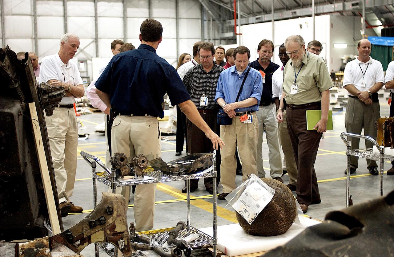 KENNEDY SPACE CENTER, FLA. -   Adm. Harold Gehman, far left, chairman of the Columbia Investigation Accident Board, looks at pieces of Columbia debris collected in the KSC RLV Hangar.  Other members of the board accompanied him as part of the ongoing investigation.  Recovery efforts as of May 5 included 82,500 pieces of debris weighing 84,800 pounds, almost 40 percent of the total dry weight of the shuttle.  About 25,000 personnel took part, utilizing almost 1.5 million total man-hours in the recovery effort and involving more than 130 federal, state and local agencies.  The operation was also supported by more than 270 organizations that included businesses and volunteer groups.