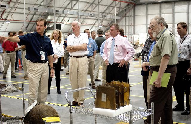 NASA image: KENNEDY SPACE CENTER, FLA. -  Adm. Harold Gehman, center left, chairman of the Columbia Investigation Accident Board, and U.S. Representative Tom Feeney, center right, are shown pieces of Columbia debris collected in the KSC RLV Hangar.  Other members of the board accompanied Gehman as part of the ongoing investigation.  Recovery efforts as of May 5 included 82,500 pieces of debris weighing 84,800 pounds, almost 40 percent of the total dry weight of the shuttle.  About 25,000 personnel took part, utilizing almost 1.5 million total man-hours in the recovery effort and involving more than 130 federal, state and local agencies.  The operation was also supported by more than 270 organizations that included businesses and volunteer groups.