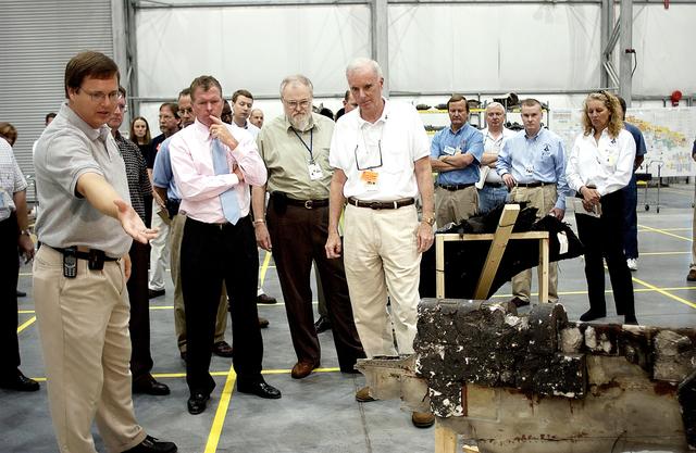 NASA image: KENNEDY SPACE CENTER, FLA. - Adm. Harold Gehman, center left, chairman of the Columbia Investigation Accident Board, and U.S. Representative Tom Feeney, center right, are shown pieces of Columbia debris collected in the KSC RLV Hangar.  Other members of the board accompanied Gehman as part of the ongoing investigation.  Recovery efforts as of May 5 included 82,500 pieces of debris weighing 84,800 pounds, almost 40 percent of the total dry weight of the shuttle.  About 25,000 personnel took part, utilizing almost 1.5 million total man-hours in the recovery effort and involving more than 130 federal, state and local agencies.  The operation was also supported by more than 270 organizations that included businesses and volunteer groups.