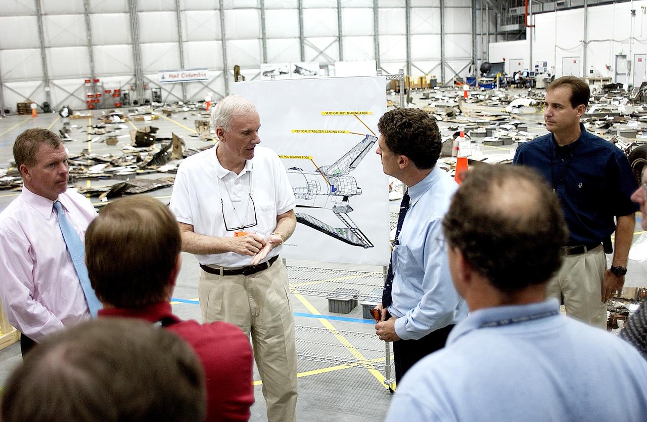 KENNEDY SPACE CENTER, FLA. - Adm. Harold Gehman, center, chairman of the Columbia Investigation Accident Board,  talks to U.S. Representative Dave Weldon (right) during the CAIB’s visit to the KSC RLV Hangar.  Left of Gehman is U.S. Representative Tom Feeney.  Gehman and the board visited the Hangar as part of the ongoing investigation.  Recovery efforts as of May 5 included 82,500 pieces of debris weighing 84,800 pounds, almost 40 percent of the total dry weight of the shuttle.  About 25,000 personnel took part, utilizing almost 1.5 million total man-hours in the recovery effort and involving more than 130 federal, state and local agencies.  The operation was also supported by more than 270 organizations that included businesses and volunteer groups.