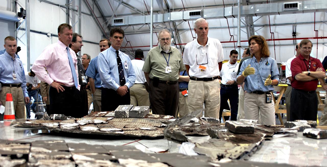 KENNEDY SPACE CENTER, FLA. - In the RLV Hangar,  members of the Columbia Investigation Accident Board look at pieces of tile from Columbia.  In the center is the chairman,  Adm. Harold Gehman, accompanied by U.S. Representatives Tom Feeney (second from left) and Dave Weldon (next to him).   Gehman and other board members are visiting KSC as part of the ongoing investigation.   Recovery efforts as of May 5 included 82,500 pieces of debris weighing 84,800 pounds, almost 40 percent of the total dry weight of the shuttle.  About 25,000 personnel took part, utilizing almost 1.5 million total man-hours in the recovery effort and involving more than 130 federal, state and local agencies.  The operation was also supported by more than 270 organizations that included businesses and volunteer groups.