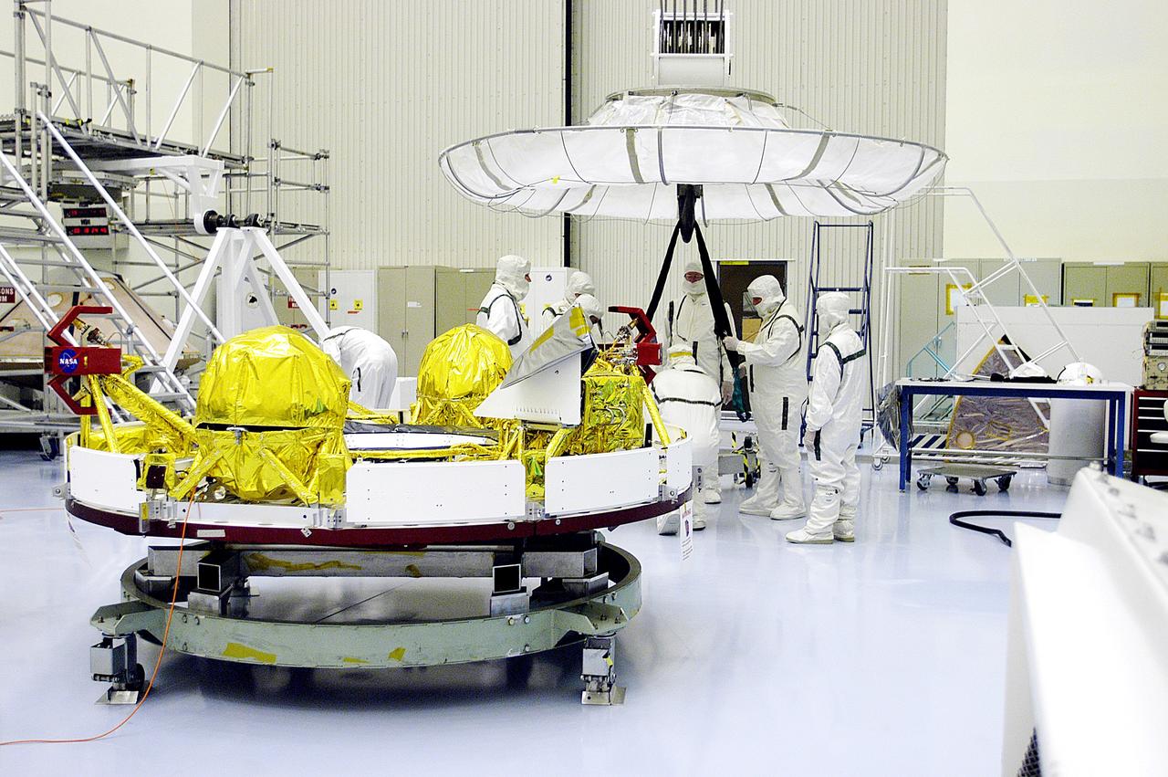 KENNEDY SPACE CENTER, FLA. -  Workers in the Payload Hazardous Servicing Facility prepare an overhead crane (background) that will lift the cruise stage, in the foreground, for Mars Exploration Rover 1 (MER-1).  The cruise stage will be moved and integrated with the aeroshell, the entry vehicle.   NASA’s twin Mars Exploration Rovers are designed to study the history of water on Mars. These robotic geologists are equipped with a robotic arm, a drilling tool, three spectrometers, and four pairs of cameras that allow them to have a human-like, 3D view of the terrain. Each rover could travel as far as 100 meters in one day to act as Mars scientists' eyes and hands, exploring an environment where humans can’t yet go.  The MER-1 is scheduled to launch June 25 from Launch Pad 17-A, Cape Canaveral Air Force Station.