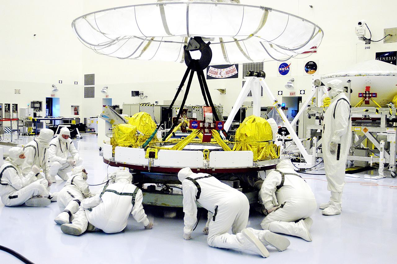 KENNEDY SPACE CENTER, FLA. - Workers in the Payload Hazardous Servicing Facility check the cruise stage of Mars Exploration Rover 1 (MER-1) that will be lifted and moved by the overhead crane for integration with the aeroshell, the entry vehicle.  NASA’s twin Mars Exploration Rovers are designed to study the history of water on Mars. These robotic geologists are equipped with a robotic arm, a drilling tool, three spectrometers, and four pairs of cameras that allow them to have a human-like, 3D view of the terrain. Each rover could travel as far as 100 meters in one day to act as Mars scientists' eyes and hands, exploring an environment where humans can’t yet go.  The MER-1 is scheduled to launch June 25 from Launch Pad 17-A, Cape Canaveral Air Force Station.