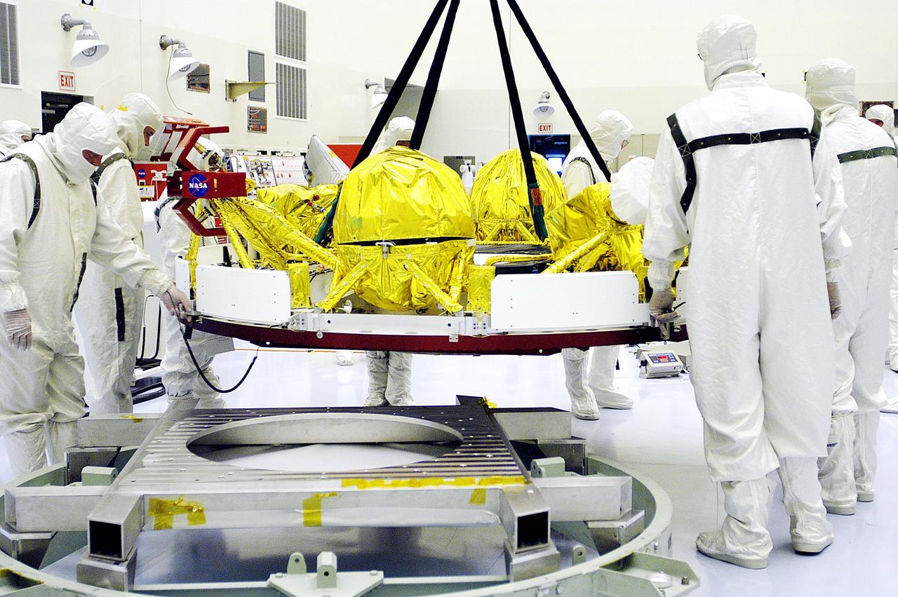 KENNEDY SPACE CENTER, FLA. - In the Payload Hazardous Servicing Facility, workers oversee the movement of the cruise stage of Mars Exploration Rover 1 (MER-1).  The cruise stage will be integrated with the aeroshell, the entry vehicle.   NASA’s twin Mars Exploration Rovers are designed to study the history of water on Mars. These robotic geologists are equipped with a robotic arm, a drilling tool, three spectrometers, and four pairs of cameras that allow them to have a human-like, 3D view of the terrain. Each rover could travel as far as 100 meters in one day to act as Mars scientists' eyes and hands, exploring an environment where humans can’t yet go.  The MER-1 is scheduled to launch June 25 from Launch Pad 17-A, Cape Canaveral Air Force Station.