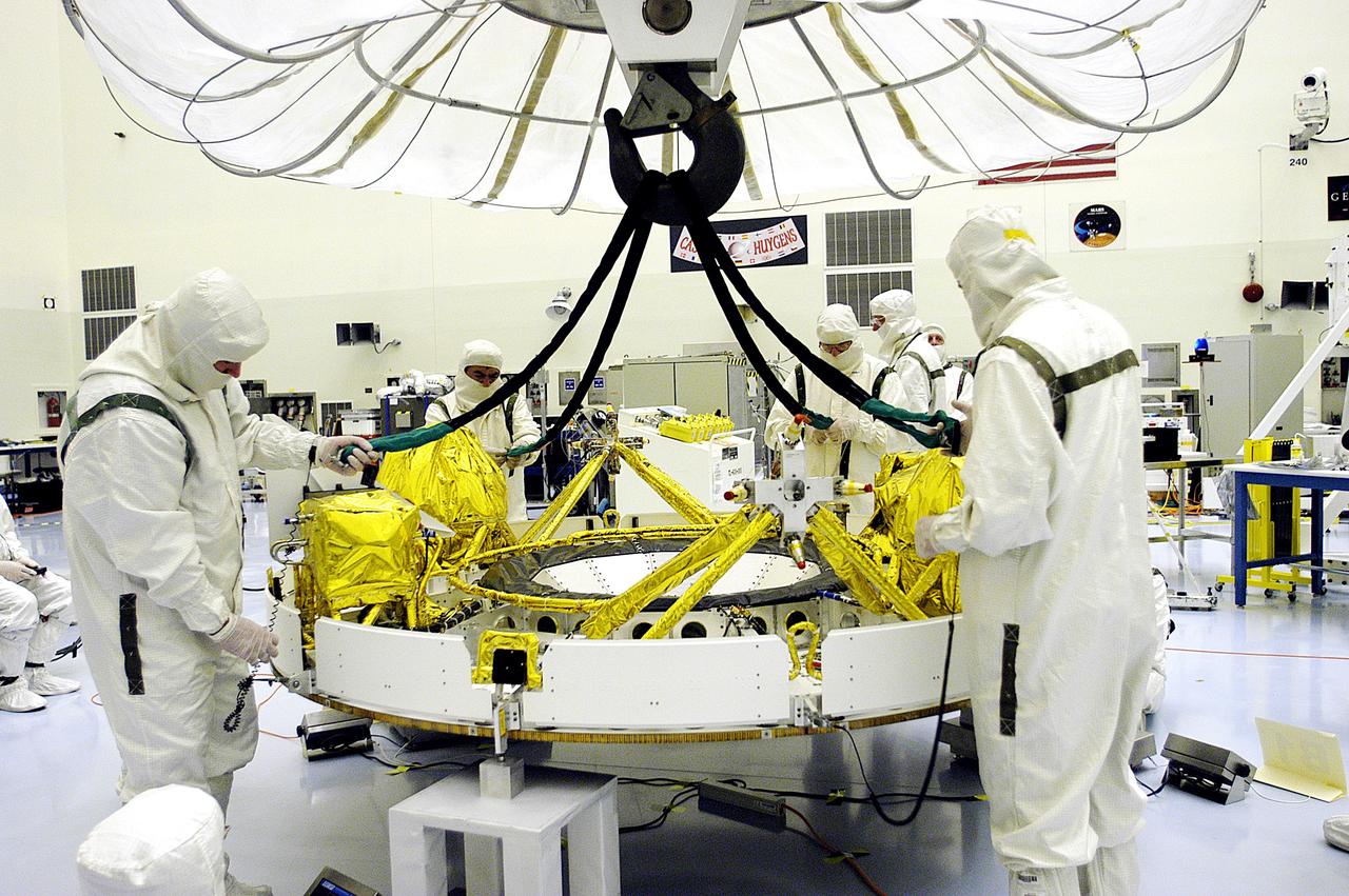 KENNEDY SPACE CENTER, FLA. - In the Payload Hazardous Servicing Facility, workers reattach the tethers of the overhead crane that lowered the cruise stage of Mars Exploration Rover 1 (MER-1) onto blocks.  The cruise stage will be lifted and integrated with the aeroshell, the entry vehicle.   NASA’s twin Mars Exploration Rovers are designed to study the history of water on Mars. These robotic geologists are equipped with a robotic arm, a drilling tool, three spectrometers, and four pairs of cameras that allow them to have a human-like, 3D view of the terrain. Each rover could travel as far as 100 meters in one day to act as Mars scientists' eyes and hands, exploring an environment where humans can’t yet go.  The MER-1 is scheduled to launch June 25 from Launch Pad 17-A, Cape Canaveral Air Force Station.