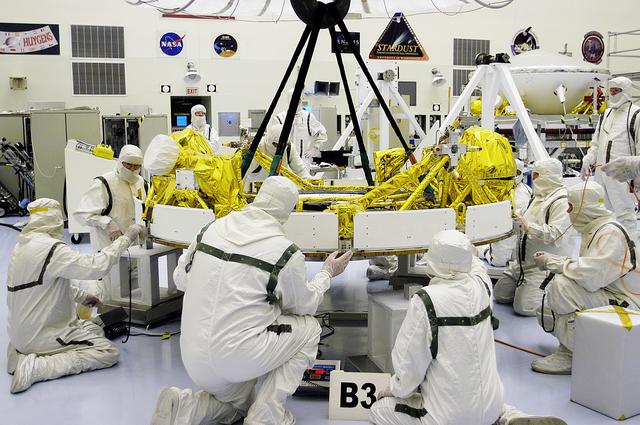 NASA image: KENNEDY SPACE CENTER, FLA. - In the Payload Hazardous Servicing Facility, workers check the status of the cruise stage of Mars Exploration Rover 1 (MER-1) after being lowered onto blocks.  The cruise stage will be integrated with the aeroshell, the entry vehicle.   NASA’s twin Mars Exploration Rovers are designed to study the history of water on Mars. These robotic geologists are equipped with a robotic arm, a drilling tool, three spectrometers, and four pairs of cameras that allow them to have a human-like, 3D view of the terrain. Each rover could travel as far as 100 meters in one day to act as Mars scientists' eyes and hands, exploring an environment where humans can’t yet go.  The MER-1 is scheduled to launch June 25 from Launch Pad 17-A, Cape Canaveral Air Force Station.