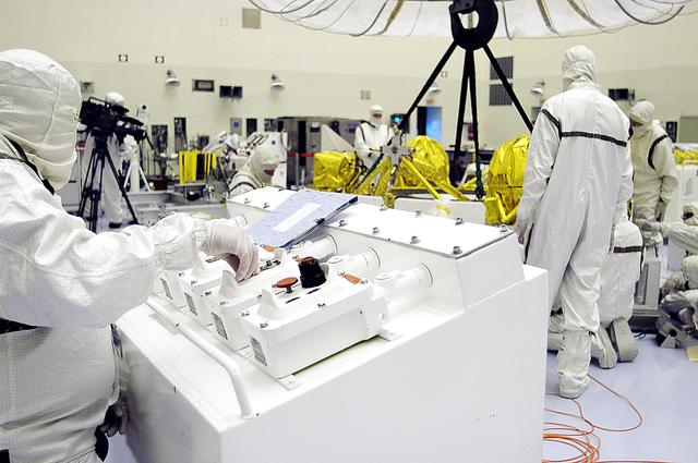 NASA image: KENNEDY SPACE CENTER, FLA. - In the Payload Hazardous Servicing Facility, workers check the status of the cruise stage of Mars Exploration Rover 1 (MER-1) after being lowered onto blocks.  The cruise stage will be integrated with the aeroshell, the entry vehicle.   NASA’s twin Mars Exploration Rovers are designed to study the history of water on Mars. These robotic geologists are equipped with a robotic arm, a drilling tool, three spectrometers, and four pairs of cameras that allow them to have a human-like, 3D view of the terrain. Each rover could travel as far as 100 meters in one day to act as Mars scientists' eyes and hands, exploring an environment where humans can’t yet go.  The MER-1 is scheduled to launch June 25 from Launch Pad 17-A, Cape Canaveral Air Force Station.