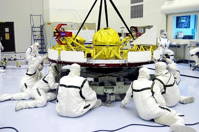 NASA image: KENNEDY SPACE CENTER, FLA. - In the Payload Hazardous Servicing Facility, workers check the cruise stage of Mars Exploration Rover 1 (MER-1) being lifted off a stand.  The cruise stage will be integrated with the aeroshell, the entry vehicle.   NASA’s twin Mars Exploration Rovers are designed to study the history of water on Mars. These robotic geologists are equipped with a robotic arm, a drilling tool, three spectrometers, and four pairs of cameras that allow them to have a human-like, 3D view of the terrain. Each rover could travel as far as 100 meters in one day to act as Mars scientists' eyes and hands, exploring an environment where humans can’t yet go.  The MER-1 is scheduled to launch June 25 from Launch Pad 17-A, Cape Canaveral Air Force Station.