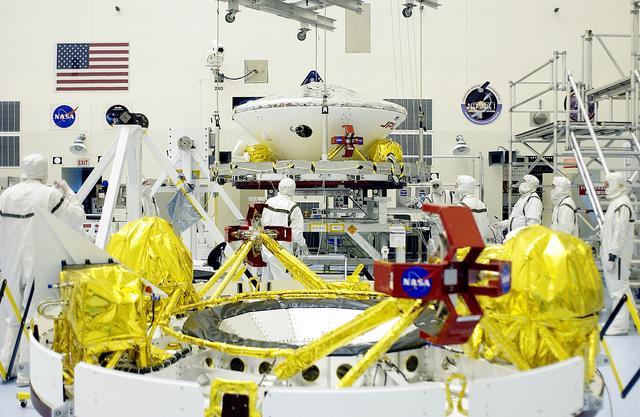 NASA image: KENNEDY SPACE CENTER, FLA. - In the Payload Hazardous Servicing Facility, an overhead crane (background) is lifting the Mars Exploration Rover 2 (MER-2) to move it to a spin table.  In the foreground is the cruise stage for MER-1.  NASA’s twin Mars Exploration Rovers are designed to study the history of water on Mars. These robotic geologists are equipped with a robotic arm, a drilling tool, three spectrometers, and four pairs of cameras that allow them to have a human-like, 3D view of the terrain. Each rover could travel as far as 100 meters in one day to act as Mars scientists' eyes and hands, exploring an environment where humans can’t yet go.  The MER-2 is scheduled to launch June 5 from Launch Pad 17-A, Cape Canaveral Air Force Station.