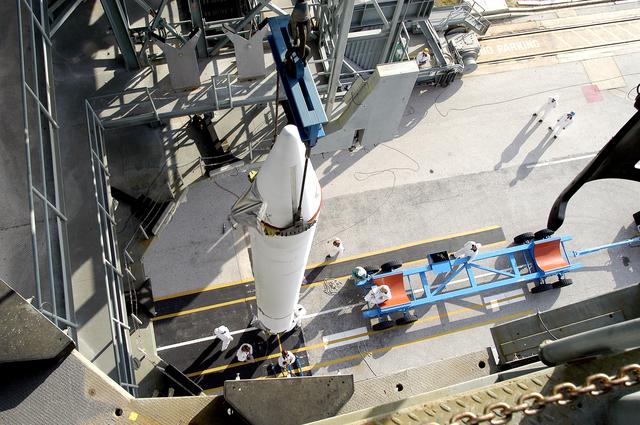 NASA image: KENNEDY SPACE CENTER, FLA. - On Launch Complex 17-B, Cape Canaveral Air Force Station, a solid rocket booster is viewed from above after being lifted to vertical.  It will be mated to the Delta II rocket for the Mars Exploration Rover 1 (MER-1) launch June 25.  NASA’s twin Mars Exploration Rovers are designed to study the history of water on Mars. These robotic geologists are equipped with a robotic arm, a drilling tool, three spectrometers, and four pairs of cameras that allow them to have a human-like, 3D view of the terrain. Each rover could travel as far as 100 meters in one day to act as Mars scientists' eyes and hands, exploring an environment where humans can’t yet go.  MER-2 (MER-A) will launch June 5.