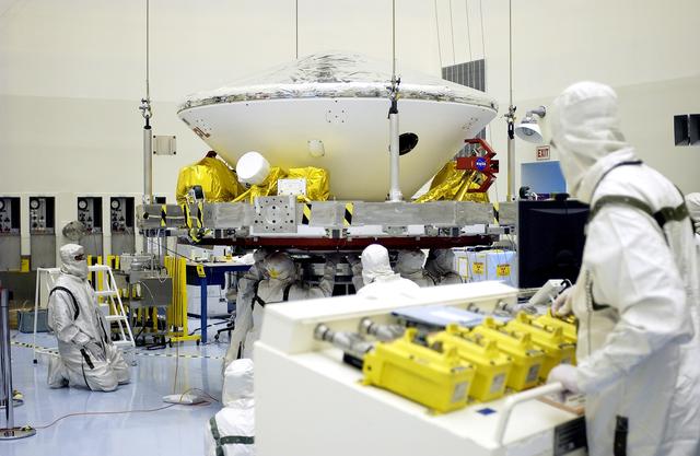NASA image: KENNEDY SPACE CENTER, FLA. -  In the Payload Hazardous Servicing Facility, workers prepare to mate the Mars Exploration Rover-2 (MER-2) to the third stage of a Delta II rocket for launch on June 5.  NASA’s twin Mars Exploration Rovers are designed to study the history of water on Mars. These robotic geologists are equipped with a robotic arm, a drilling tool, three spectrometers, and four pairs of cameras that allow them to have a human-like, 3D view of the terrain. Each rover could travel as far as 100 meters in one day to act as Mars scientists' eyes and hands, exploring an environment where humans can’t yet go.  MER-1 (MER-B) will launch June 25.
