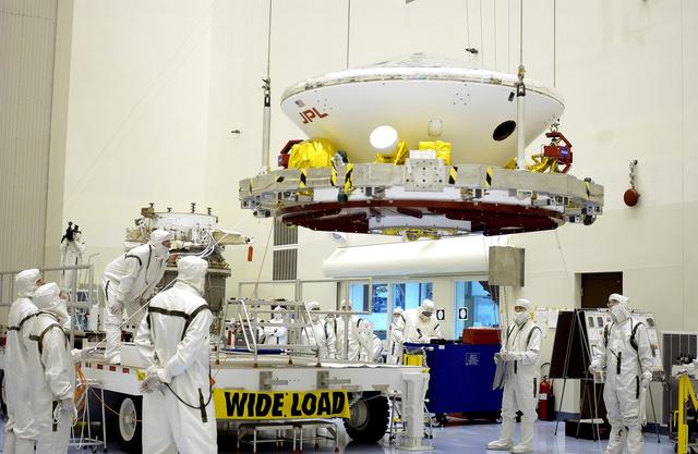 NASA image: KENNEDY SPACE CENTER, FLA. -  In the Payload Hazardous Servicing Facility, workers prepare to mate the Mars Exploration Rover-2 (MER-2) to the third stage of a Delta II rocket for launch on June 5.  NASA’s twin Mars Exploration Rovers are designed to study the history of water on Mars. These robotic geologists are equipped with a robotic arm, a drilling tool, three spectrometers, and four pairs of cameras that allow them to have a human-like, 3D view of the terrain. Each rover could travel as far as 100 meters in one day to act as Mars scientists' eyes and hands, exploring an environment where humans can’t yet go.  MER-1 (MER-B) will launch June 25.