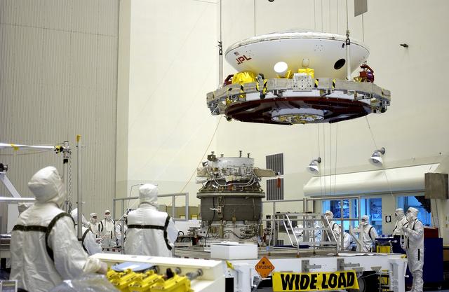 NASA image: KENNEDY SPACE CENTER, FLA. -  In the Payload Hazardous Servicing Facility, workers prepare to mate the Mars Exploration Rover-2 (MER-2) to the third stage of a Delta II rocket for launch on June 5.  NASA’s twin Mars Exploration Rovers are designed to study the history of water on Mars. These robotic geologists are equipped with a robotic arm, a drilling tool, three spectrometers, and four pairs of cameras that allow them to have a human-like, 3D view of the terrain. Each rover could travel as far as 100 meters in one day to act as Mars scientists' eyes and hands, exploring an environment where humans can’t yet go.  MER-1 (MER-B) will launch June 25.